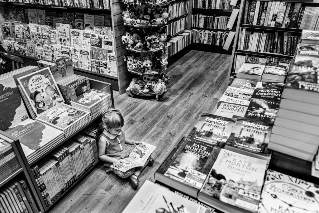 dziecko w księgarni czyta książkę